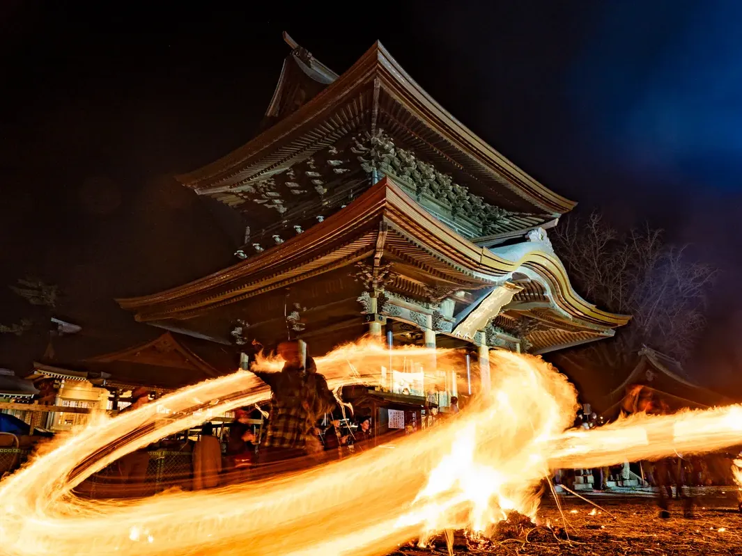 火振り神事の炎と神社の社殿