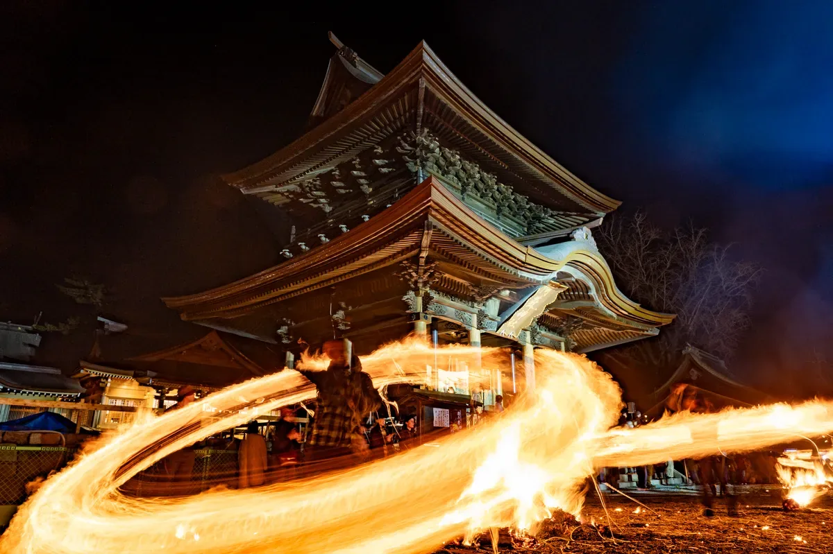 夜の神社で炎が円を描く火振り神事 — HIBURIの社名の由来